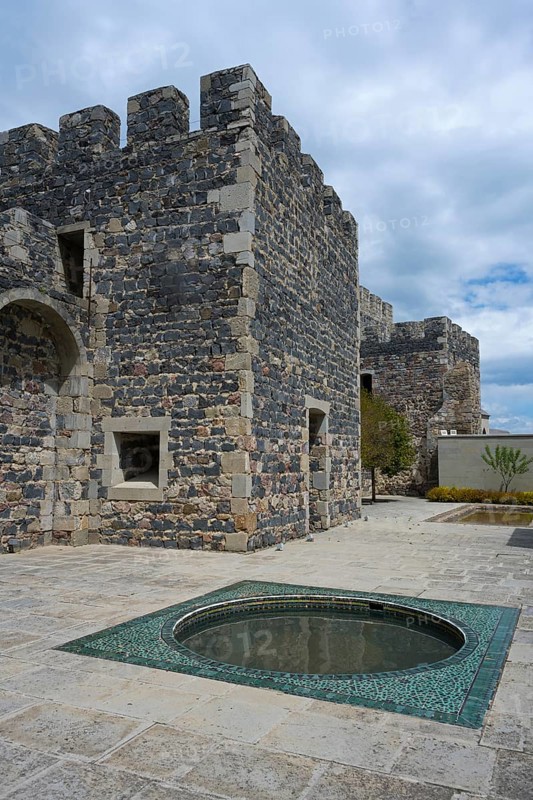 Part of a massive stone castle with battlements and a decorative fountain in the courtyard, Rabati Fortress, Akhaltsikhe, Samtskhe-Javakheti region, Samtskhe-Javakheti, Georgia