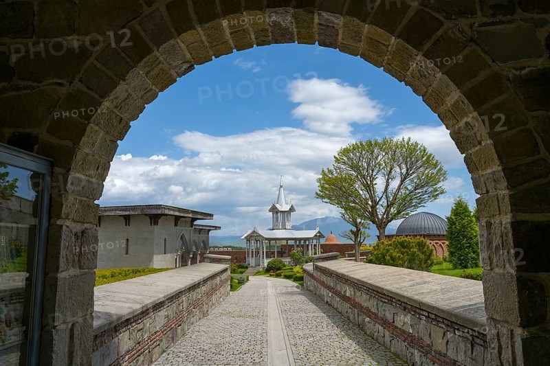 Buildings seen through a stone arch, with a cloudy sky and trees, Rabati Fortress, Akhaltsikhe, Samtskhe-Javakheti region, Samtskhe-Javakheti, Georgia