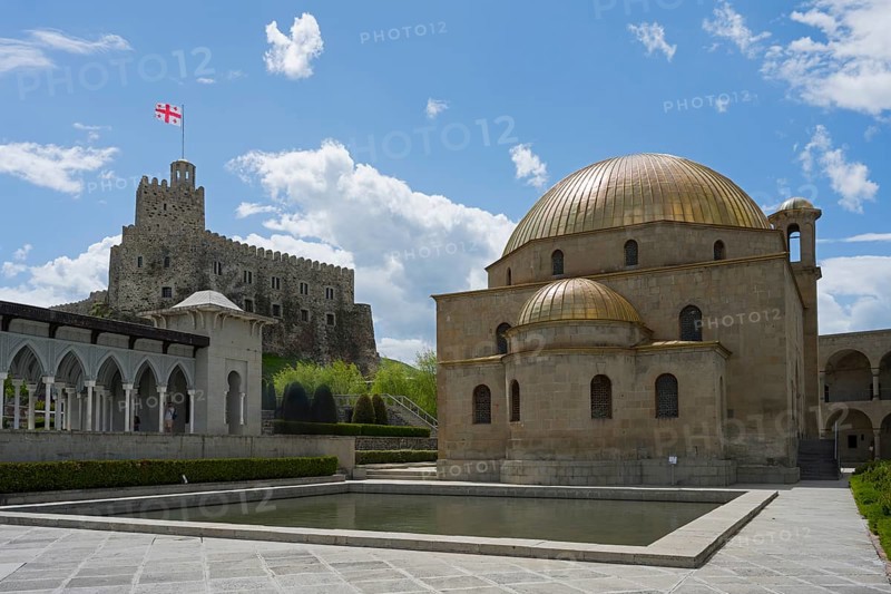 Mosque with golden dome in front of a stone castle with flag under clear sky, Rabati Fortress, Akhaltsikhe, Samtskhe-Javakheti region, Samtskhe-Javakheti, Georgia