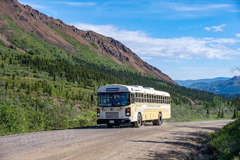 Tourist bus, national park bus on a dirt road, mountainous landscape, Denali Park Road, Denali National Park and Preserve, Alaska, USA