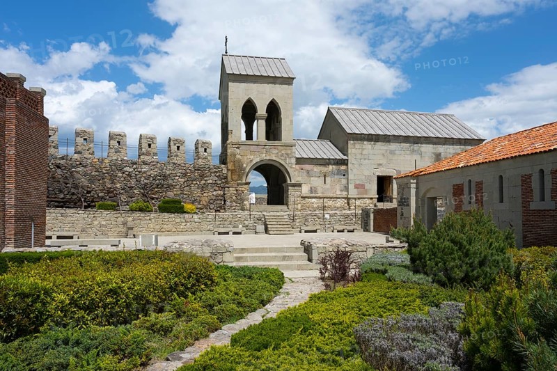 Historic church building with bell tower and adjoining garden under blue sky, Rabati Fortress, Akhaltsikhe, Samtskhe-Javakheti region, Samtskhe-Javakheti, Georgia