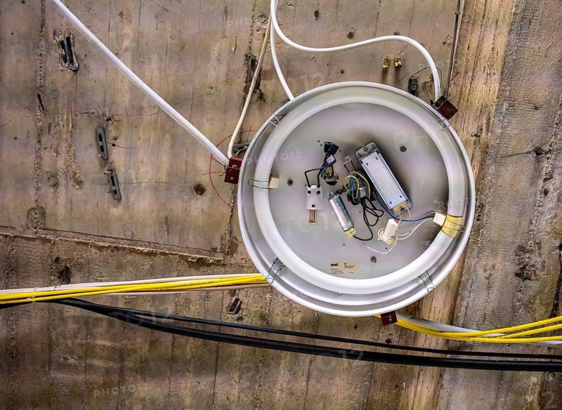 Old neon tube ceiling lamp hanging on a bare concrete ceiling, Berlin, Germany