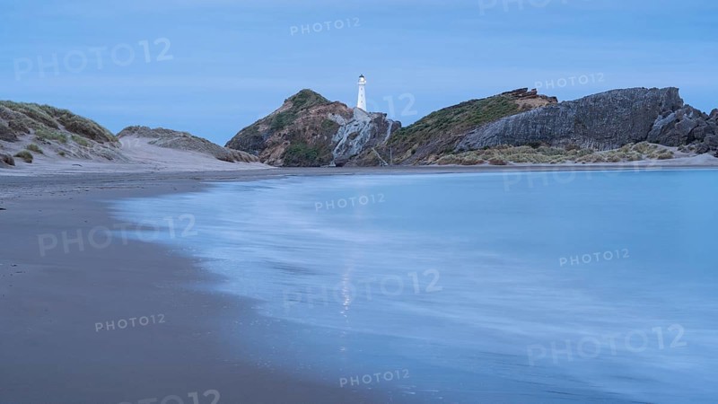Deliverance Cove and Castlepoint Lighthouse on the rock, ocean, long exposure, evening, illuminated. Castlepoint, Wairarapa Coast, Wellington Region, North Island, New Zealand