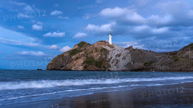 Castlepoint Beach, ocean and lighthouse on a rock, in the evening, after sunset. Castlepoint, Wairarapa Coast, Wellington Region, North Island, New Zealand