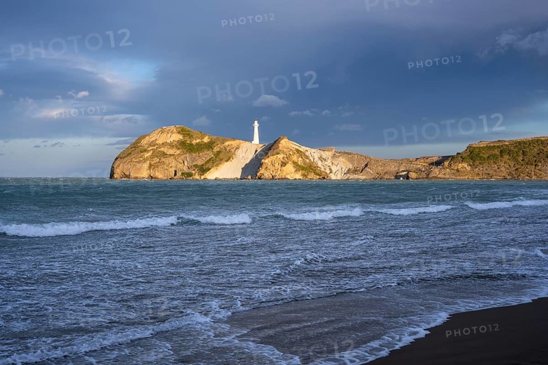 Castlepoint Beach, ocean and lighthouse on a rock, in the evening. Castlepoint, Wairarapa Coast, Wellington Region, North Island, New Zealand