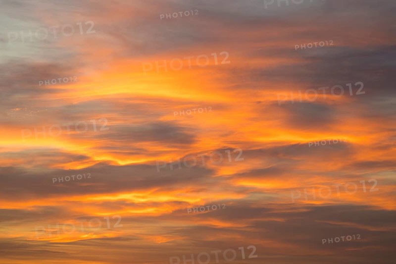 Abstract cloud formations in bright orange against a pastel colored sky, Baden-Württemberg, Germany