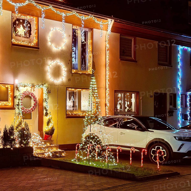 Christmassy kitschy illuminated façade of a row house in Gelsenkirchen-Ückendorf in the evening, Ruhr area, North Rhine-Westphalia, Germany