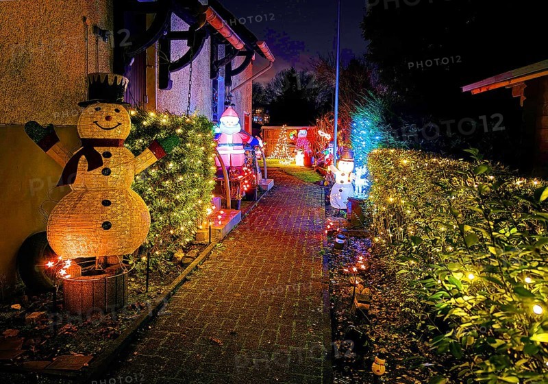 Christmassy kitschy illuminated entrance of a terraced house in Gelsenkirchen-Ückendorf in the evening, Ruhr area, North Rhine-Westphalia, Germany