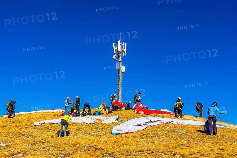Paragliders prepare for takeoff below the transmitter and cell phone tower, summit of the Corne de Sorebois, Val d'Anniviers, Valais Alps, Canton of Valais, Switzerland
