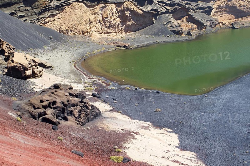 Volcanic crater and green lagoon with contrasting colors and rock formations, El Golfo, Lanzarote Canary Island
