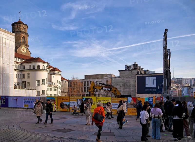 Passers-by, excavator, construction site, construction fence, controversial construction project of the bankrupt company Signa by René Benko, logo, ongoing insolvency proceedings, agency ZWEIHOCHFÜNF, former Galeria Kaufhof, Königsstraße, Schulstraße, pedestrian zone, collegiate church, Stuttgart, Baden-Württemberg, Germany