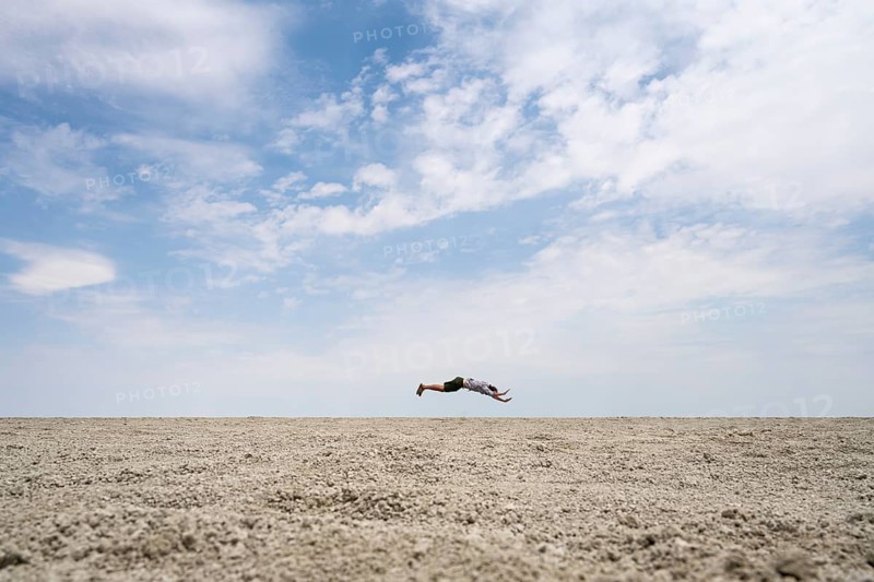 Abstract, man jumping horizontally at the Etosha pan, salt pan, Etosha National Park, Namibia