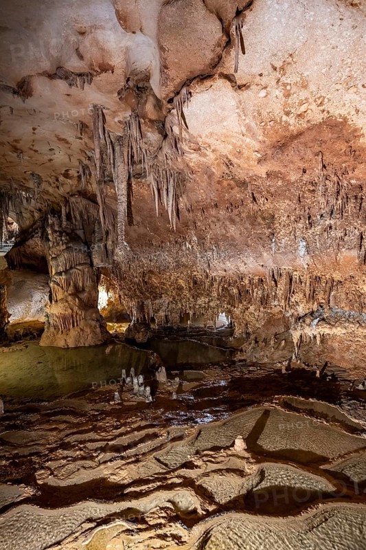 Stalactites and stalagmites, rock formations in a stalactite cave with water basin, Grotta del Fico, Gulf of Orosei, Baunei, Sardinia, Italy