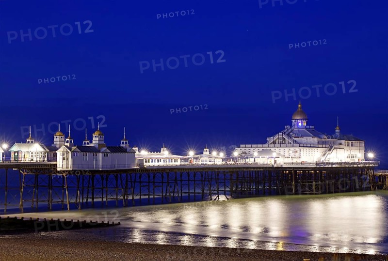 An illuminated pier stretches across the calm sea at night, Bournemouth, England, Great Britain