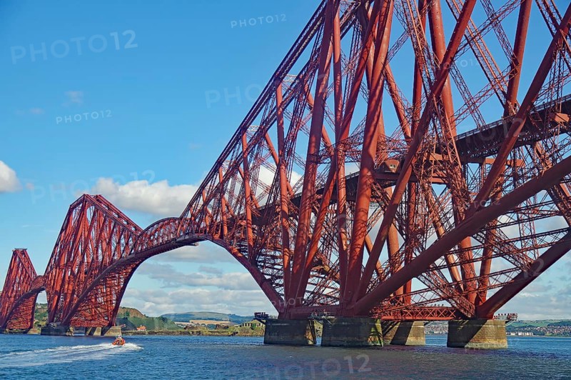 An imposing red steel bridge spanning a river under a blue sky, railway bridge, Firth of Forth, Edinburgh, Scotland, Great Britain
