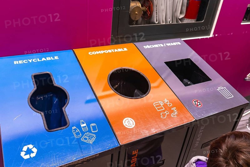 Colorful recycling bins at an airport promoting waste separation into recyclable, compostable, and general waste, enhancing responsible disposal and environmental sustainability