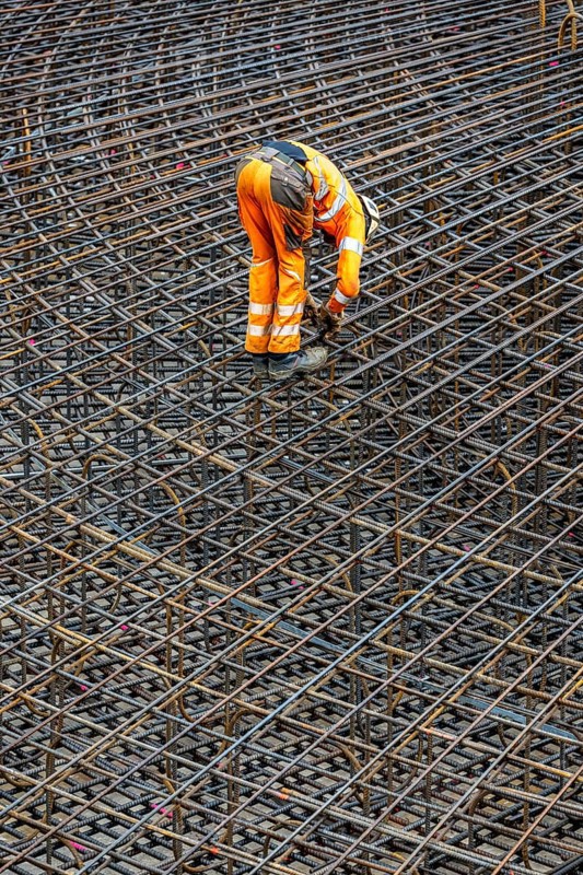 Assembly of reinforcing steel for the reinforced concrete foundation of a wind turbine, a mesh of rebar and reinforcing steel mesh, connecting the steel elements with binding wire, twisting with tongs, over 100 tons of reinforcing steel were used, the wind turbine will have a hub height of 160 meters, part of a new wind farm in Sauerland, near Balve, North Rhine-Westphalia, Germany