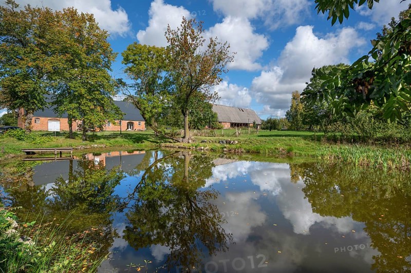 Historic horse stable and barn with pond, 1923, at the Othenstorf estate, Othenstorf, Mecklenburg-Western Pomerania, Germany