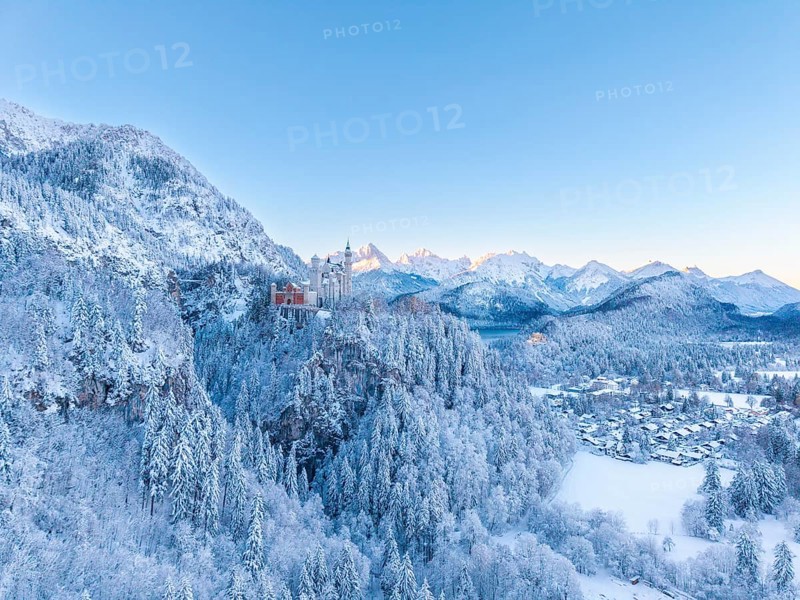 Neuschwanstein Castle is nestled in a quiet, snow-covered alpine landscape at dawn, Schwangau near Füssen, Ostallgäu, Allgäu, Bavaria, Germany