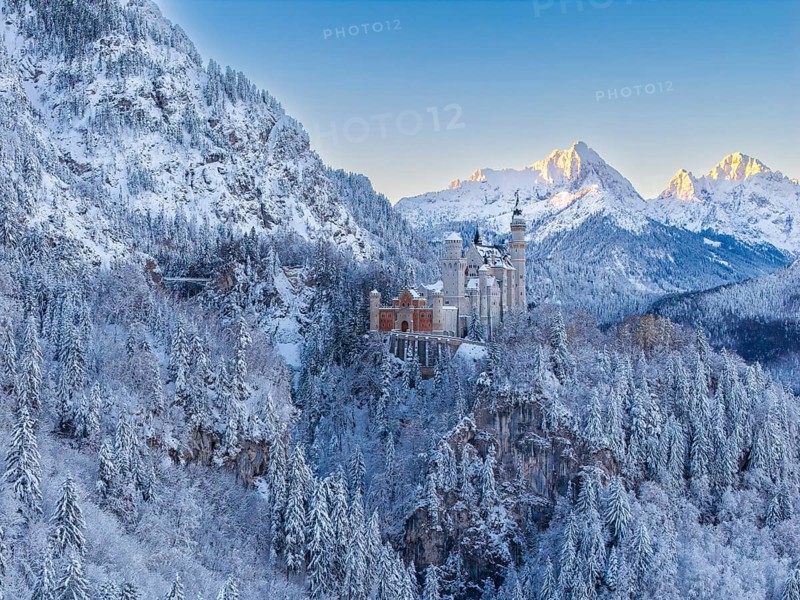 The magnificent Neuschwanstein Castle, surrounded by mountains and glowing snow in the morning light, atmospheric, Schwangau near Füssen, Ostallgäu, Allgäu, Bavaria, Germany