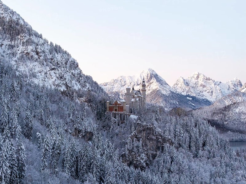 Magnificent Neuschwanstein Castle in the midst of a snowy mountain landscape with majestic peaks, Schwangau near Füssen, Ostallgäu, Allgäu, Bavaria, Germany