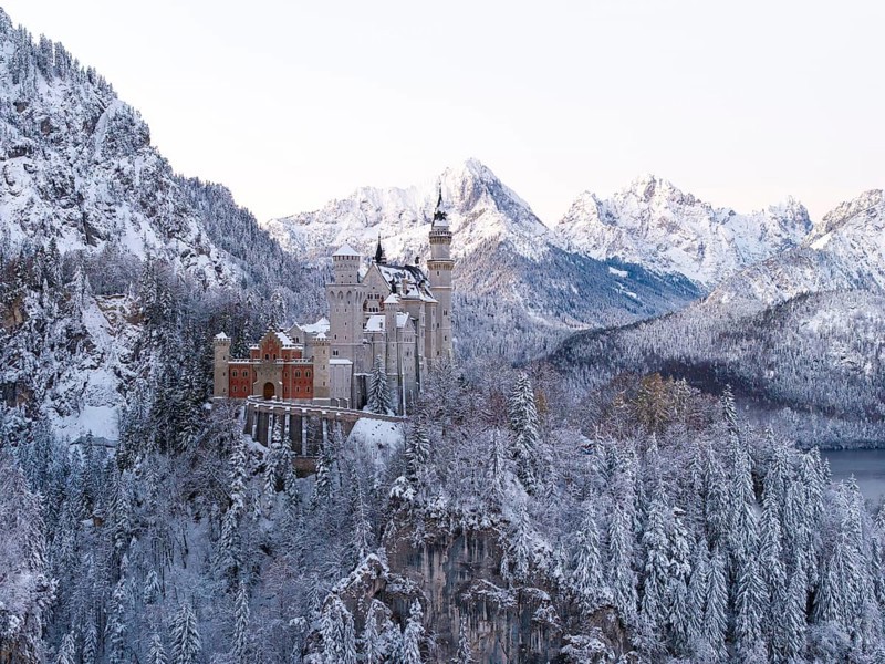 Neuschwanstein Castle sits majestically in the midst of a snowy, alpine winter landscape, Schwangau near Füssen, Ostallgäu, Allgäu, Bavaria, Germany