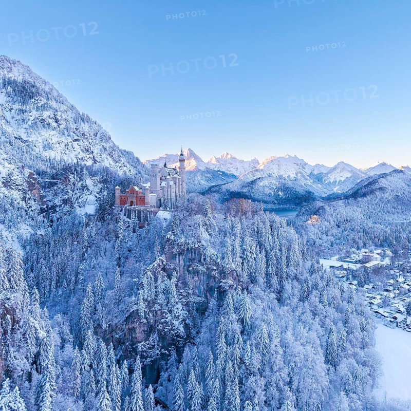 Neuschwanstein Castle rises above a snowy mountain landscape, wrapped in the cold of winter morning, Schwangau near Füssen, Ostallgäu, Allgäu, Bavaria, Germany