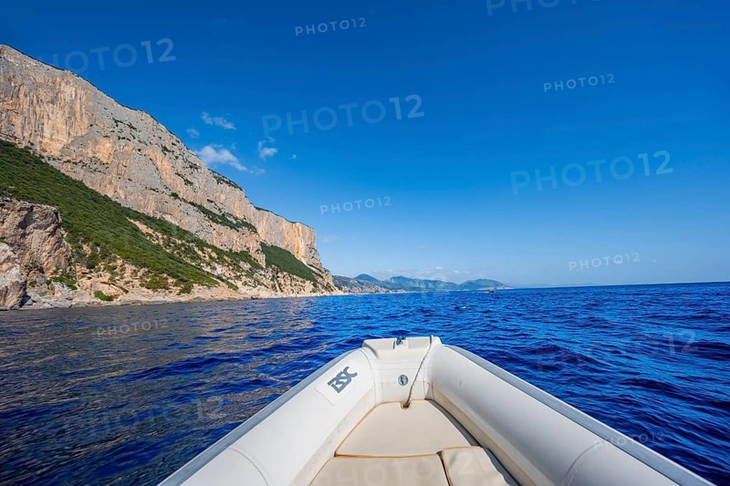 Motorboat trip along the picturesque rocky coast, cliffs and blue sea, Golfo di Orosei, Baunei, Sardinia, Italy