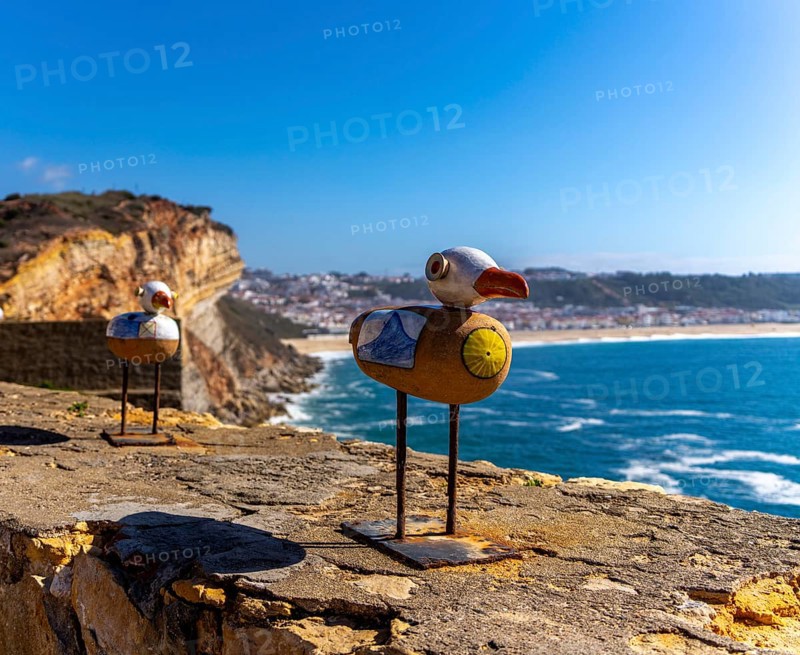 Wooden seagulls, art on the fortress at Farol de Nazare lighthouse, an annual meeting place in autumn to watch the big waves on the North Beach, Nazaré, Portugal