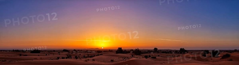 A calming sunrise over the desert that makes the sky shine in vivid colors, Sahara in Morocco