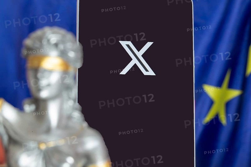 Symbolic picture of the EU Commission's fine against X: Justice, smartphone with logo of X and EU flag