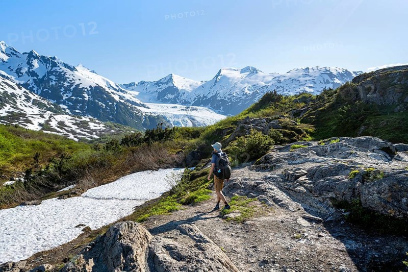 Hikers on the Portage Pass Trail, snow-covered mountains and Portage Glacier glaciers, near Whittier, Alaska, USA