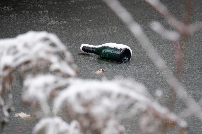 Symbolic picture of garbage in nature, bottle on frozen lake, winter, Germany