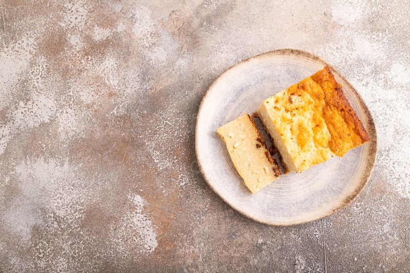 ?ottage cheese ?asserole, Curd cake, with dried apricots and raisins on brown concrete background, top view, flat lay, copy space, minimalism