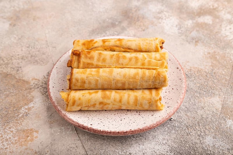 Waffles with caramel on brown concrete background, side view, close up