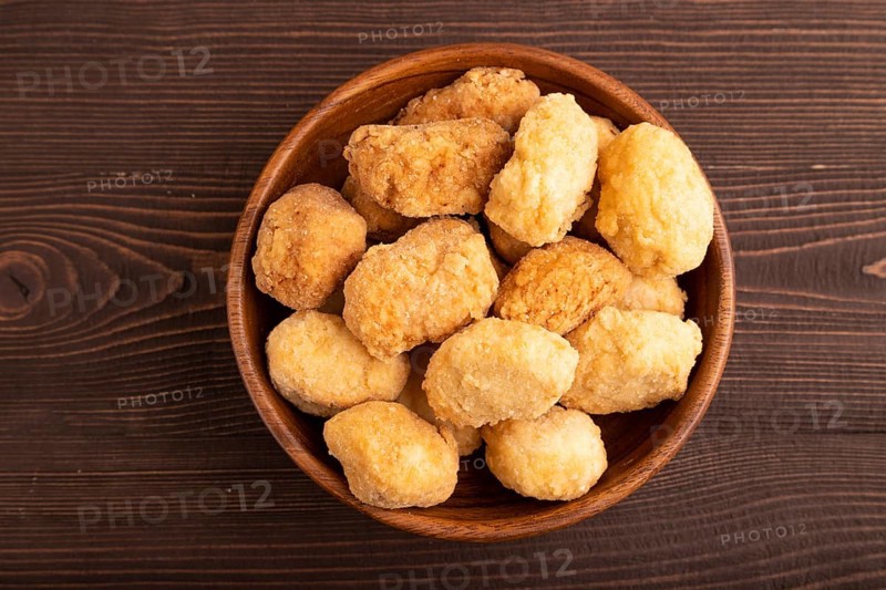Fried crispy Chicken Nuggets on brown wooden background. top view, flat lay, copy space