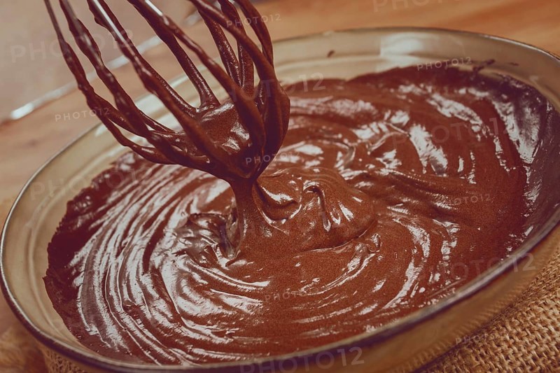 A bowl of chocolate dough, a whisk for whipping, baking, structure and consistency, homemade, top view, no people