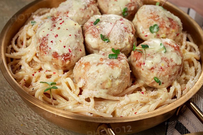Spaghetti with chicken meatballs, with cream sauce, and parmesan cheese, and decorated with microgreens, homemade, no people