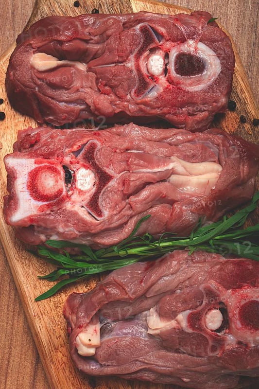 Raw steak, calf's neck on the bone, fresh meat, on the cutting board, top view, no people