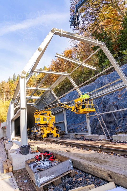 Construction work at a tunnel entrance in autumn with yellow construction equipment and visible nature in the background, Hermann Hesse Railway bat tunnel construction site, Calw, Black Forest, Germany