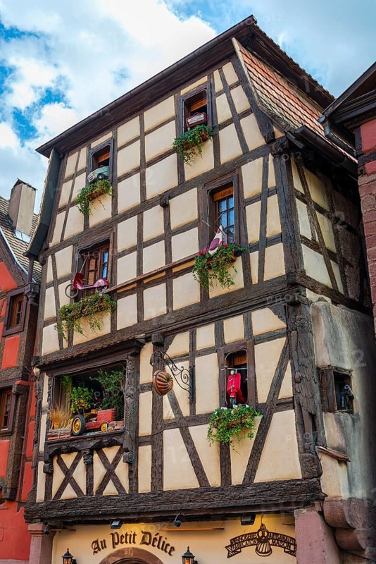 Timber-frame house decorated with vehicles in the historic old town of Riquewihr, Ellsass