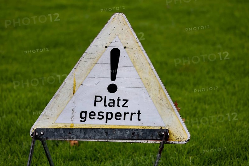 Sign with the inscription PLACE BLOCKED on a sports field (symbol image)