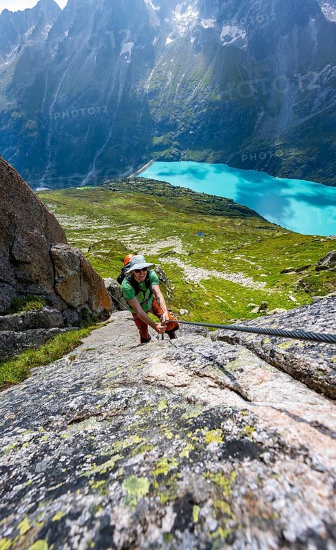 Mountaineer climbs on the secured Schijen-Zwärg via ferrata, climb to Bergseehütte, Göscheneralp in the back, Canton of Uri, Switzerland
