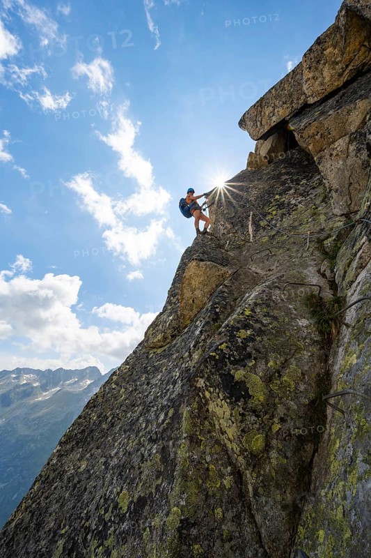 Female mountaineer on steep rock face on the secured via ferrata Krokodil-Bergsee am Bergseeschijen-Vorbau, Sonnenstern, Göscheneralp, Canton of Uri, Switzerland