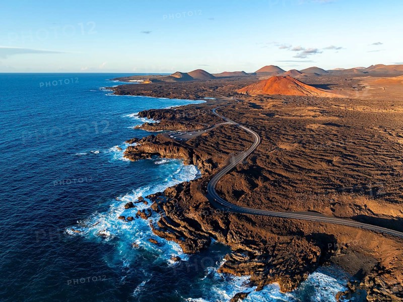 Coast with lava fields, volcanic landscape near Los Hervideros with red volcano Montaña Bermeja, in the evening light, aerial view, Lanzarote, Canary Islands, Spain