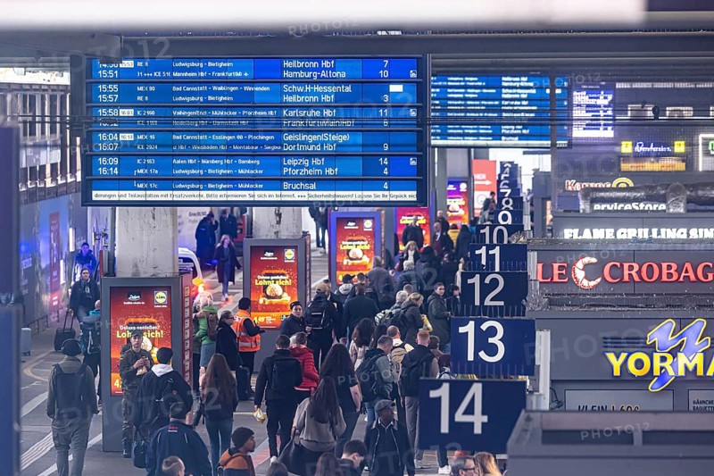 Travelers at the main train station, passengers and departure board at Stuttgart main station. Stuttgart, Baden-Württemberg, Germany