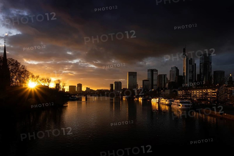 The sun sets behind the Main and bathes Frankfurt's banking skyline in orange-yellow light, Alte Brücke, Frankfurt am Main, Hesse, Germany