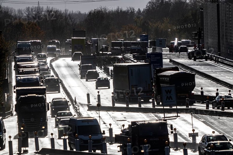 Highway construction site, the A57 is extended to 6 lanes on the section between the Meerbusch motorway junction and the Oppum junction, traffic runs parallel to 2 narrowed lanes, wet road after rain shower, Krefeld, North Rhine-Westphalia, Germany