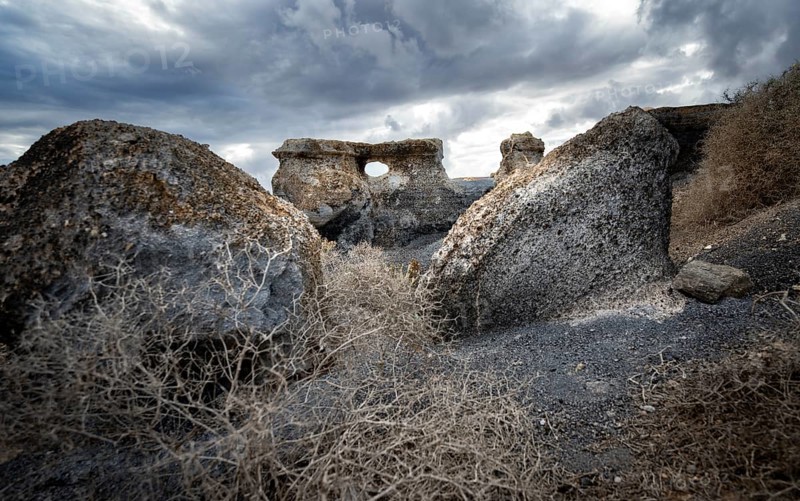 Eroded rock formations with rock tunnels, volcanic landscape with dramatic cloudy skies, Ciudad Estratificada or Los Roferos, Antigua Rofera de Teseguite, Lanzarote, Canary Islands, Spain