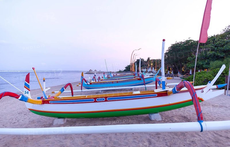 Colourfully painted outrigger fishing boats, (Junkung), on Sanur beach, Bali, Indonesia